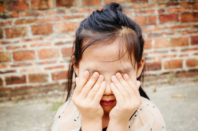 Close-up of girl covering eyes