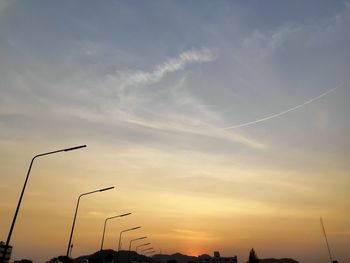 Low angle view of silhouette street light against sky