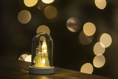 Close-up of illuminated lamp on table