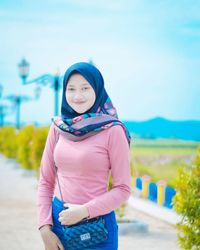 Portrait of beautiful young woman standing outdoors