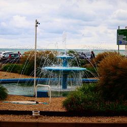 Fountain in park against sky in city