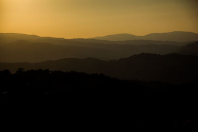 Scenic view of silhouette mountains against sky at sunset