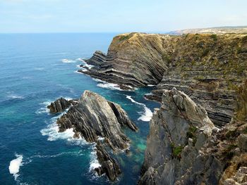 Rock formation in sea against sky