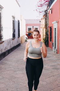 Young woman in sports clothing doing running and stretching exercises in queretaro, mexico