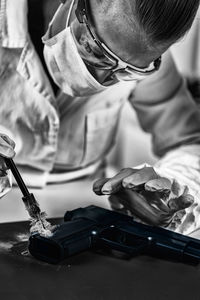 Scientist brushing handgun in laboratory