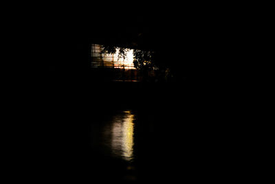 Silhouette illuminated built structure against sky at night