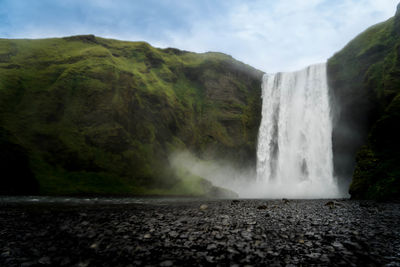 Scenic view of waterfall against sky