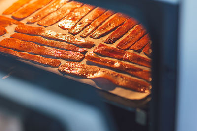 Sliced carrots in the oven on a protvin for cooking carrot bacon. vegetarian food, meat replacement