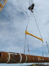 Low angle view of crane against sky