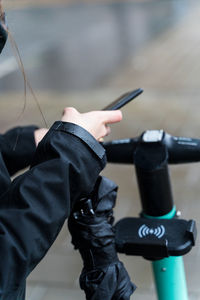 Midsection of man holding mobile phone