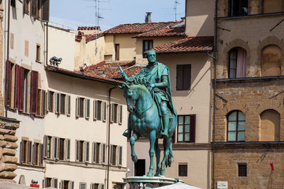 Low angle view of statue against building in city