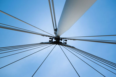 Low angle view of electricity pylon against blue sky