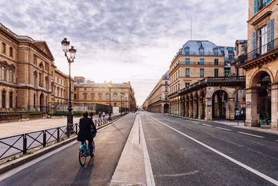 Man riding bicycle on road in city