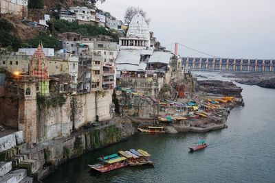 Boats moored in sea against buildings in city