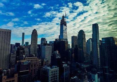 Modern buildings in city against cloudy sky