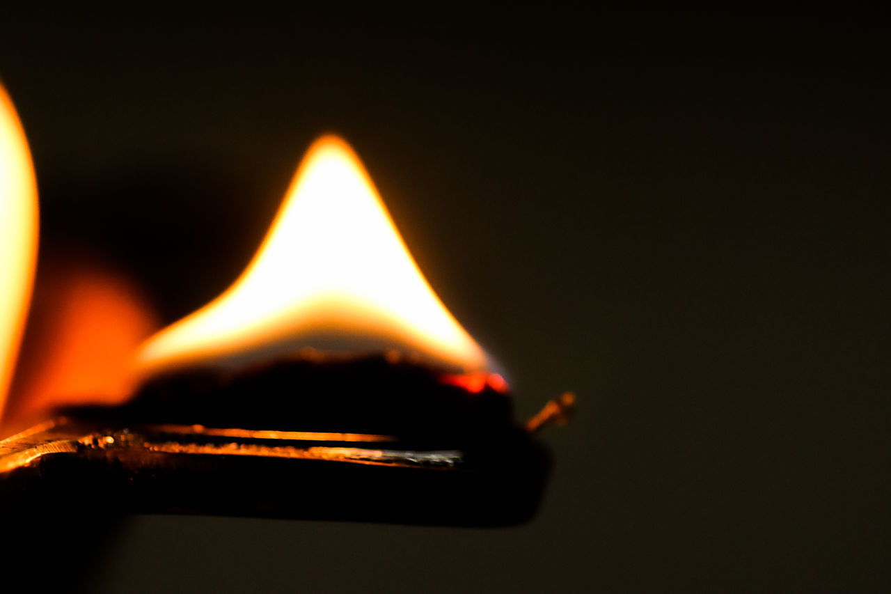 CLOSE-UP OF BURNING CANDLE