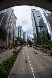 View of city street against cloudy sky