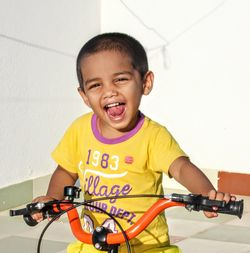 Portrait of smiling boy riding bicycle at home