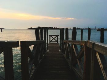 Pier over sea against sky during sunset