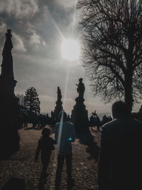 Silhouette people in park against sky in city