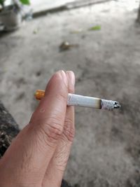 Close-up of hand holding cigarette