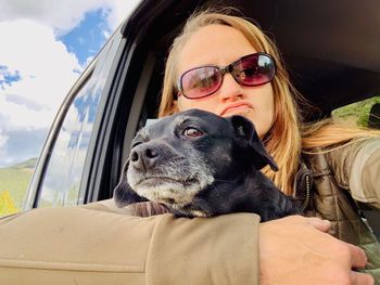 Portrait of man with dog on sunglasses