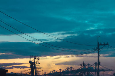 Silhouette electricity pylon against sky during sunset