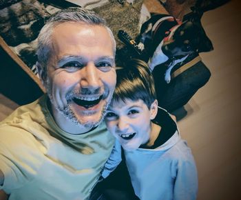 Portrait of smiling father and son at home