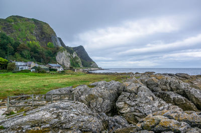 Rock formations by sea against sky