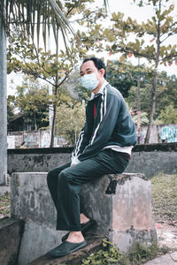 Side view of young man looking at camera