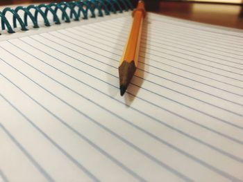 Close-up of pencil with note pad on table