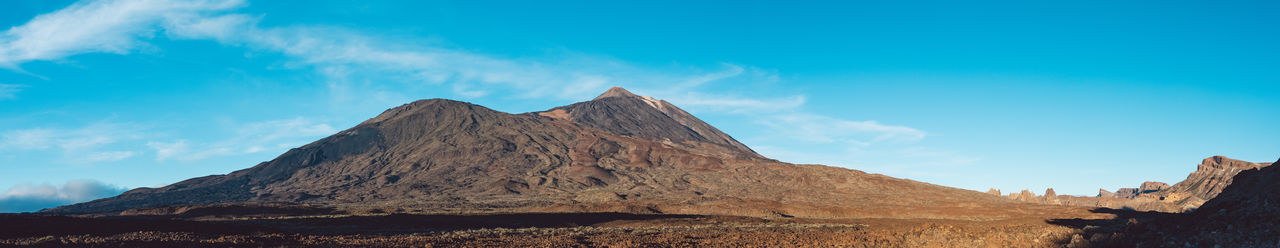 Panoramic view of mountains against blue sky