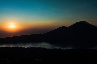 Scenic view of silhouette mountains against sky during sunset