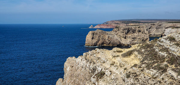 Rock formations by sea against sky