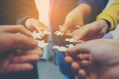 Cropped image of friends playing jigsaw puzzle