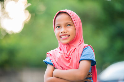 Portrait of smiling girl sitting outdoors