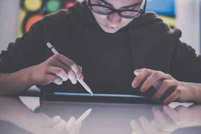 Teenager drawing with tablet and virtual pen. student doing homework with new technology devices. 