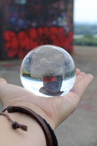 Close-up of hand holding crystal ball