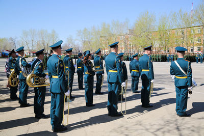 Rear view of people standing against sky