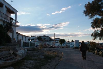 Man in city against sky