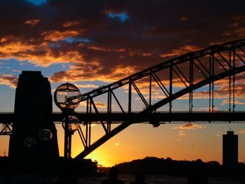 Low angle view of bridge against cloudy sky during sunset