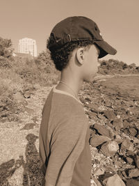 Side view of man standing on field against sky