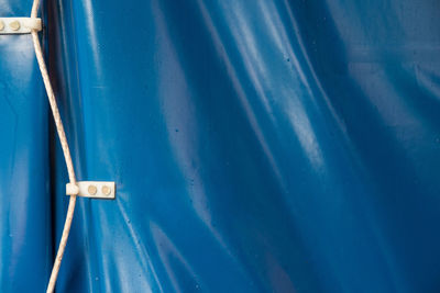 Close-up of rope in hooks on blue leather