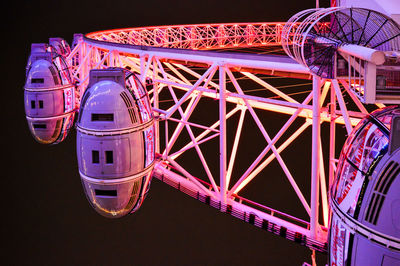 Low angle view of illuminated ferris wheel against sky at night