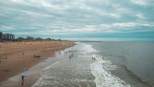 People at beach against sky