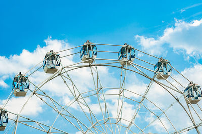 Low angle view of ferris wheel against blue sky