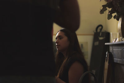 Portrait of a young woman looking away at home