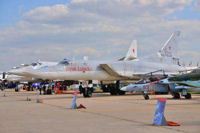 Airplane on airport runway against sky