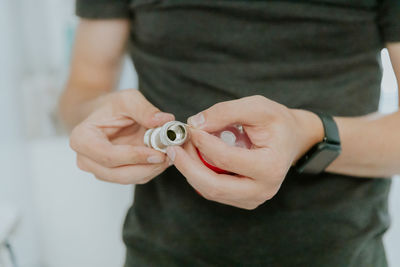 A young man wraps tow around the nut of a bathroom faucet.