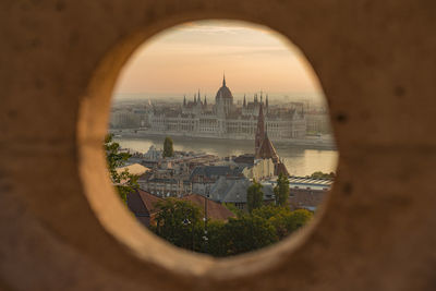 Cityscape seen through hole during sunset